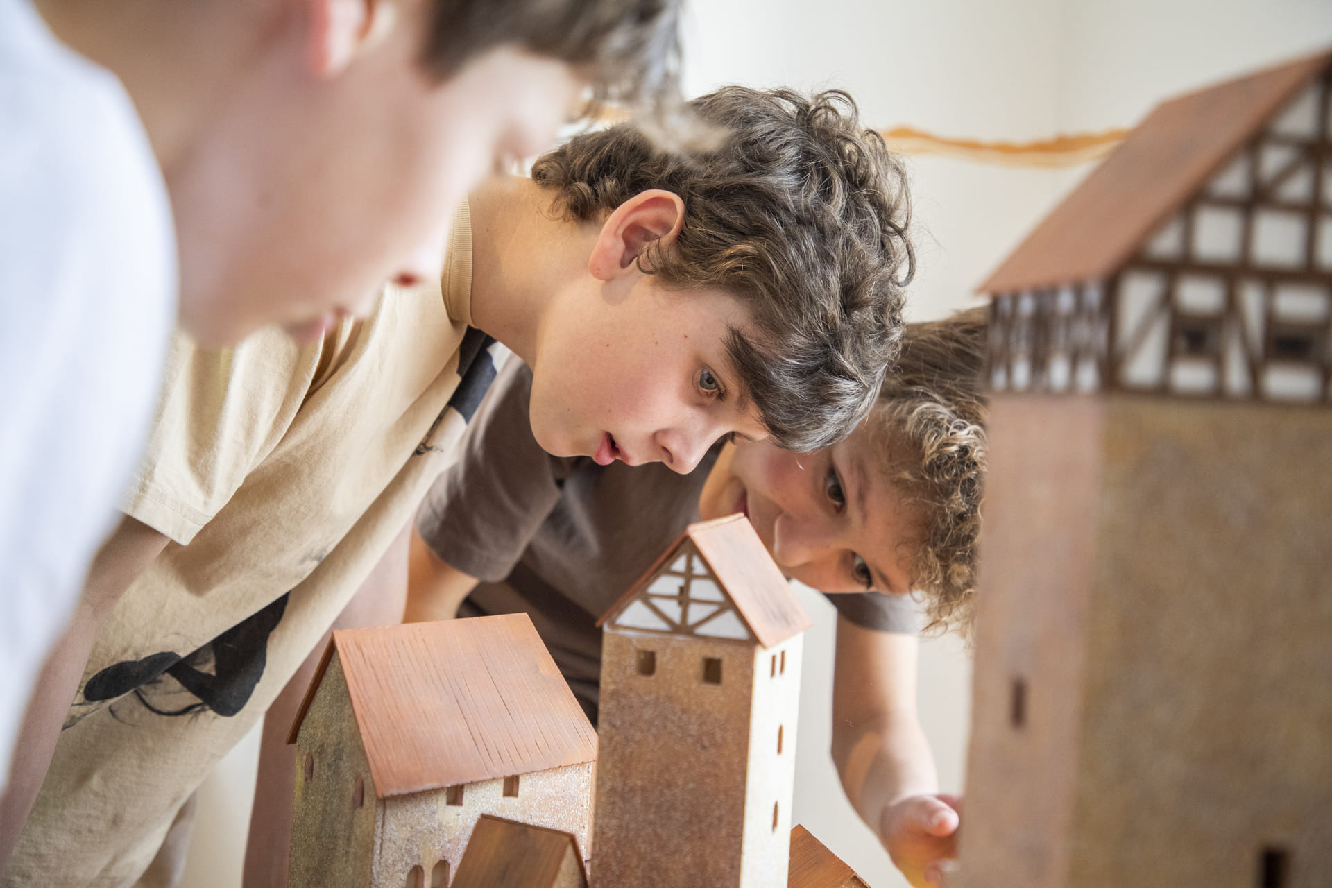 Kinder schauen sich Modelle von Burgen und Schlössern aus der Nähe an