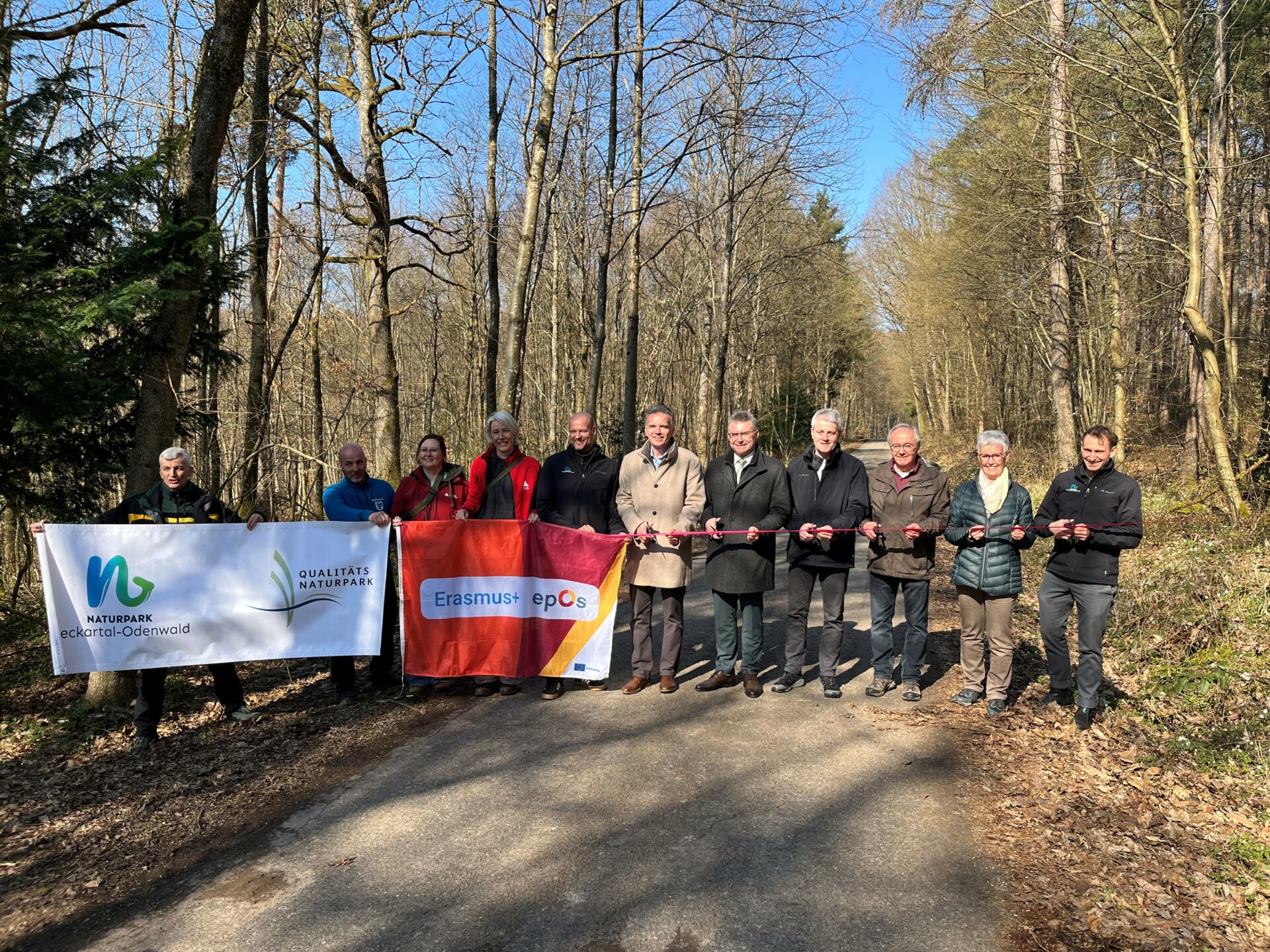 Menschen schneiden ein pinkes Band durch