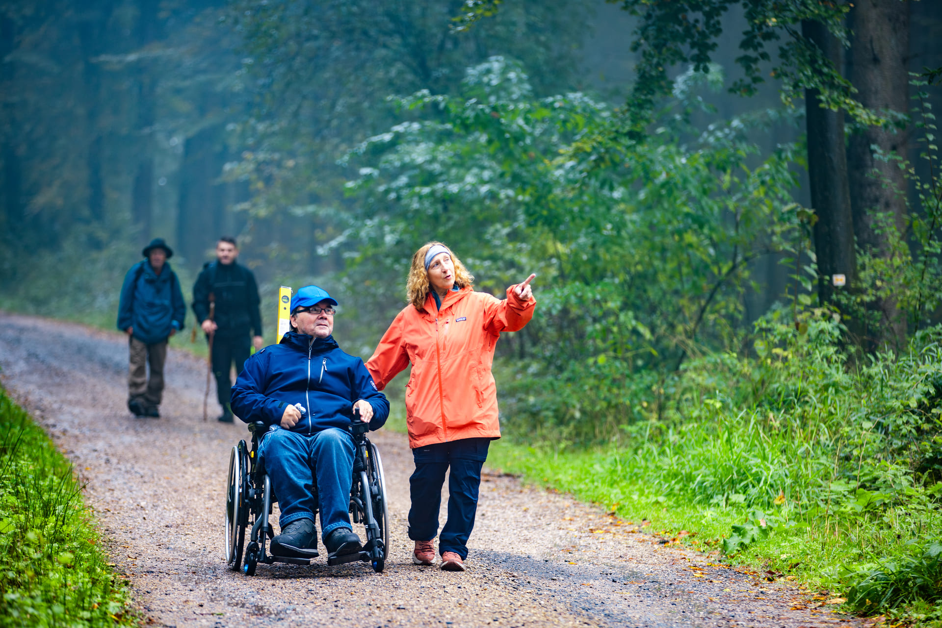 Rollstuhlfahrer und Begleitung unterwegs auf einem Komfortwanderweg im Naturpark Neckartal-Odenwald
