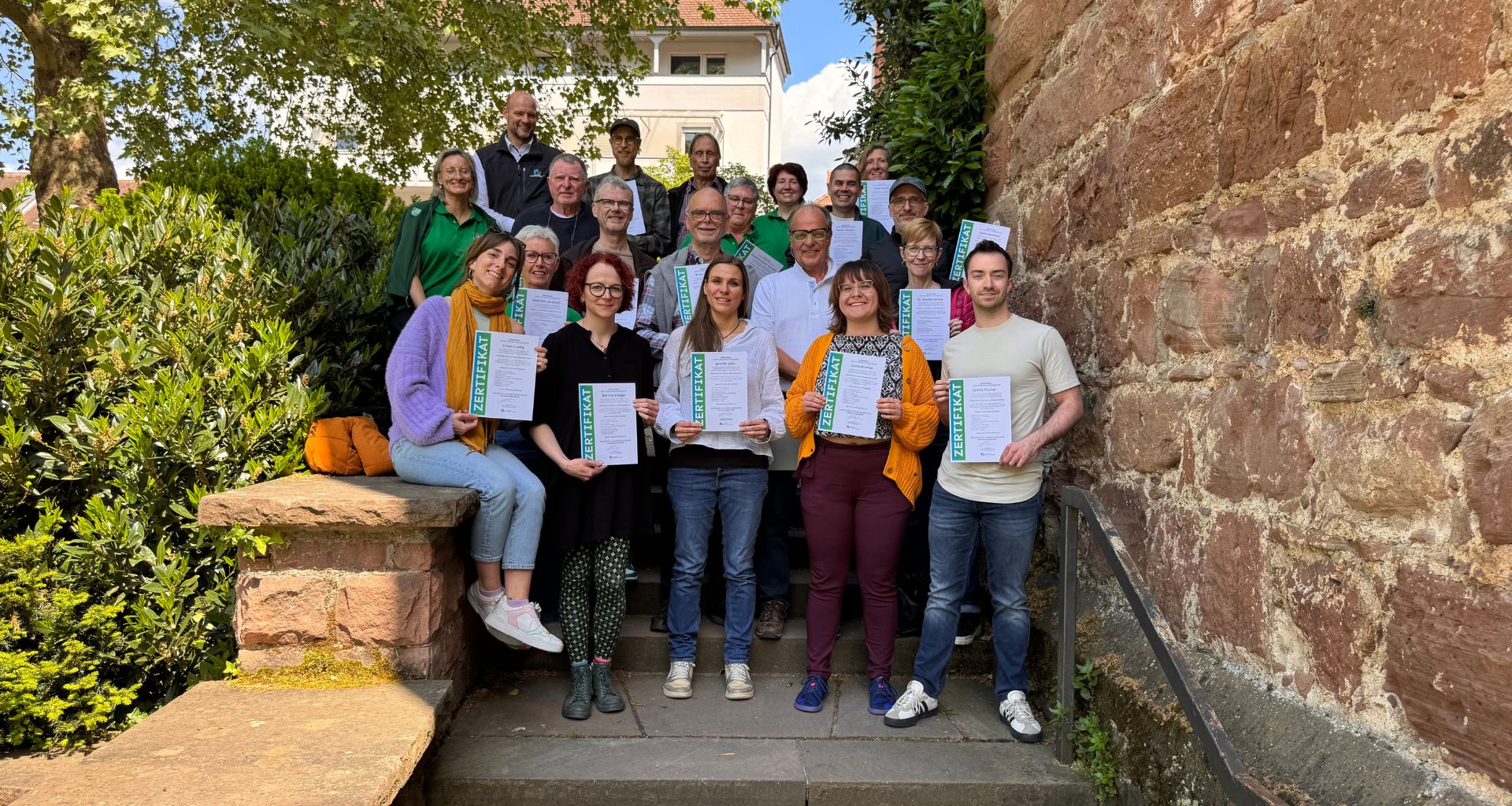Gruppenfoto von Menschen mit dem Klimabotschafter*innen-Zertifikat in der Hand