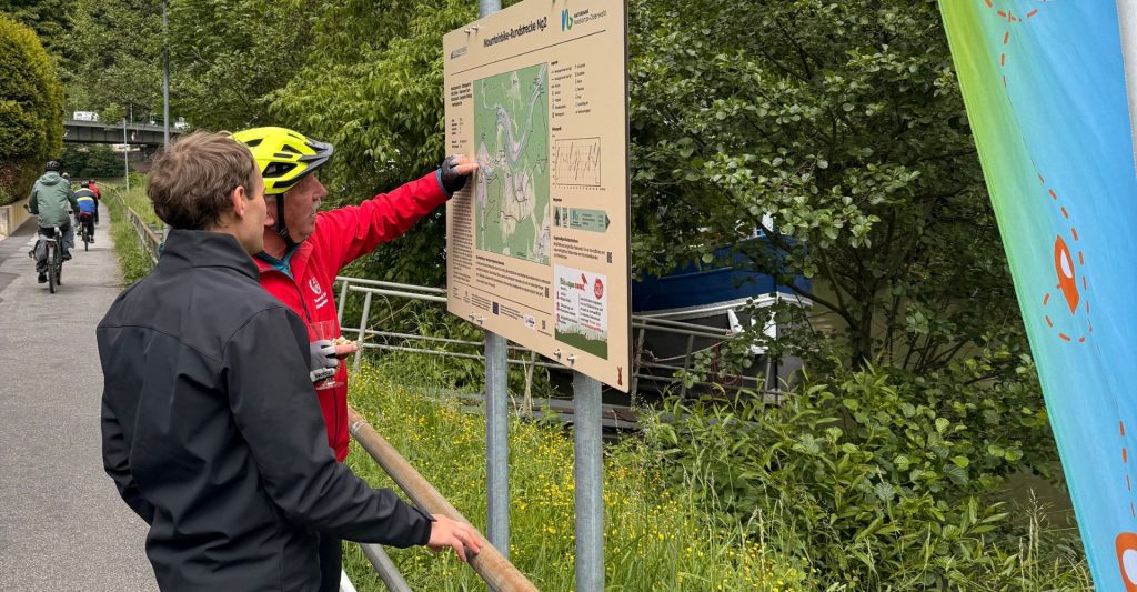 Zwei Menschen betrachten das Mountainbike-Schild in Neckargemünd
