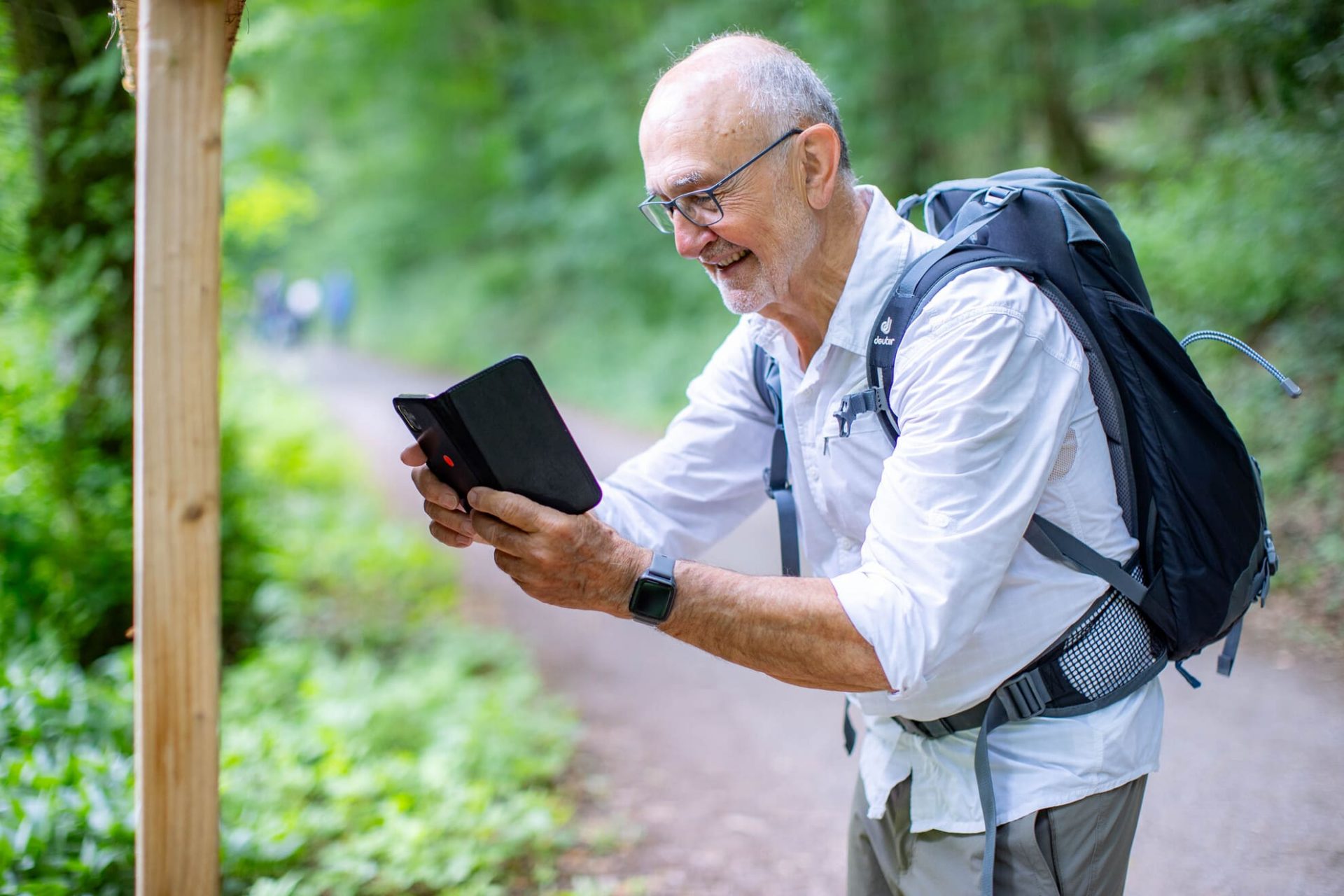 Wanderer scannt mit seinem Smartphone einen QR Code der Audiotour auf einem Komfort-Wanderweg des Naturparks