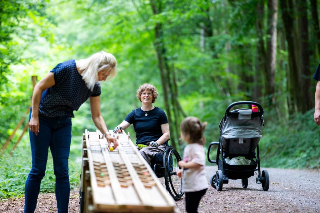 Familie an der Murmelbahn im Wald auf dem Komfort-Wanderweg 6